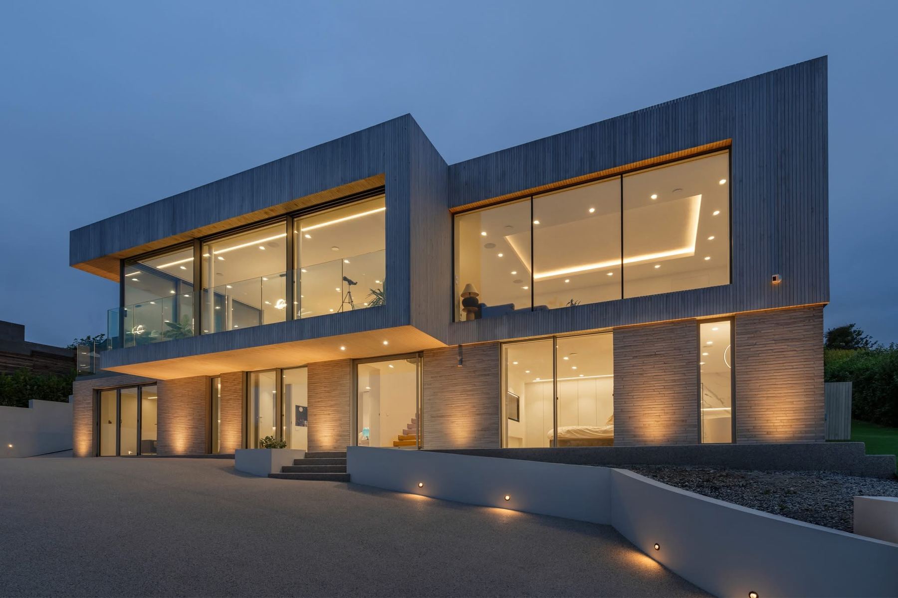 Modern North Devon home lit at dusk with architectural exterior lighting